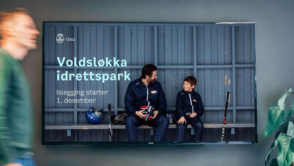 Informasjonsplakat som henger på en vegg, med fotografi av voksen og barn som sitter på en benk med hockeyutstyr.