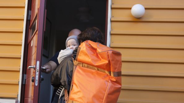 En kvinne og et barn på vei inn i et hus