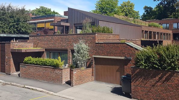 Boligbygg i tre og teglstein, med garasjeport