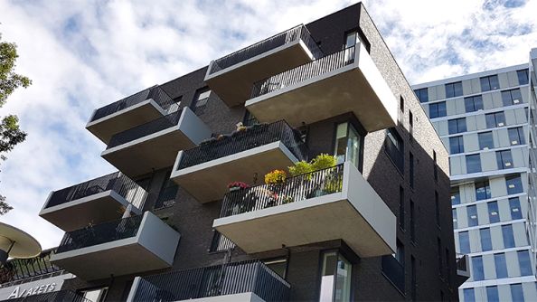 Froskefoto av steinbygg. Store balkonger som stikker langt ut fra bygget.