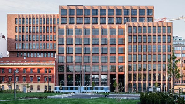 Høyt og bredt bygg i murstein, med strukturert fasade.