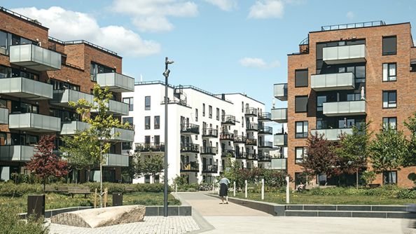 Teglsteinblokker i fem etasjer med store lysegrå balkonger