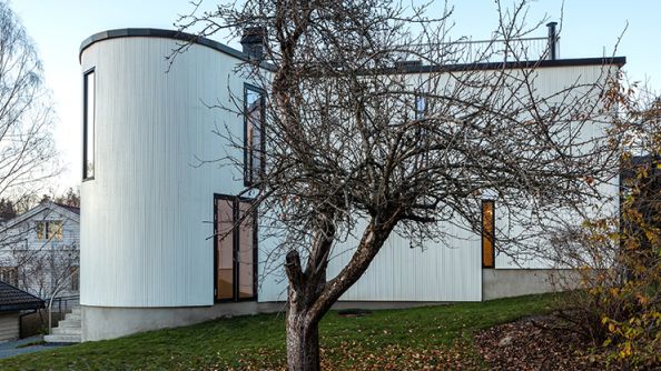 Hvit enebolig med avrundet form på venstre side.