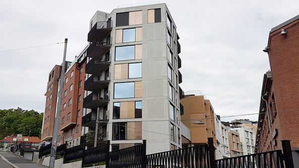 Smalt bygg på åtte etasjer med balkonger på den ene siden. Ligger i en skrå helling.