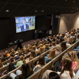 Bilde fra et seminar på Rådhuset av publikum som ser på storskjerm