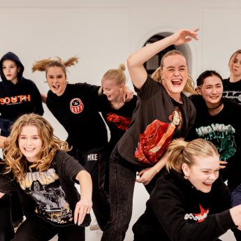 En gjeng med ungdommer danser i en dansesal