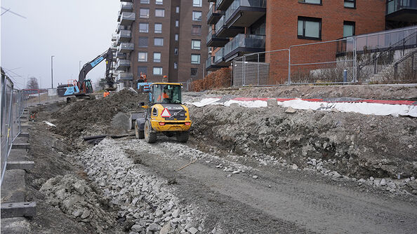 Gravearbeid i snødekt område med en gravemaskin.