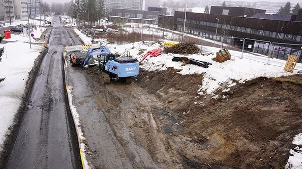 En gravemaskin gjør plass til den nye fortauet.