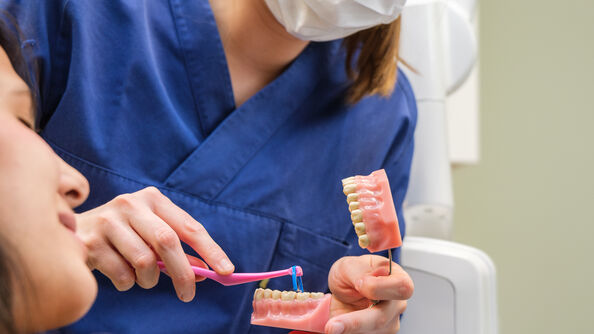 Tannpleier forklarer bruk av tanntråd