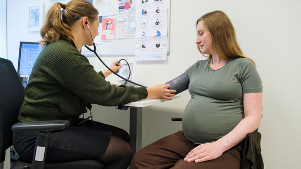 Gravid kvinne på svangerskapskontroll med jordmor