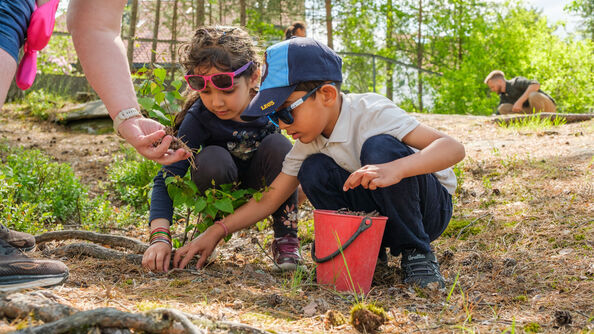 2 children leaning over the ground