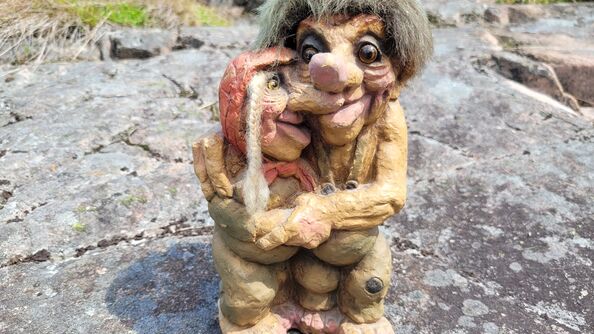 En skulptur av to troll som gir hverandre en klem.