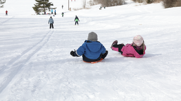 A photo of two children sledding down a hill in Oslo