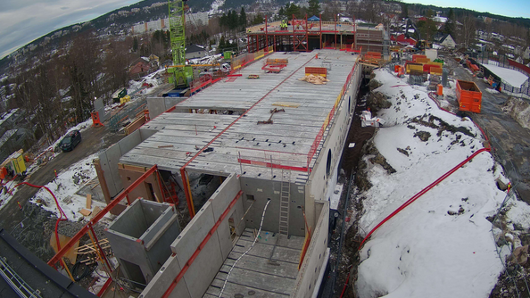Byggeplassen sett ovenfra, med et stort bygg i betong under oppføring.