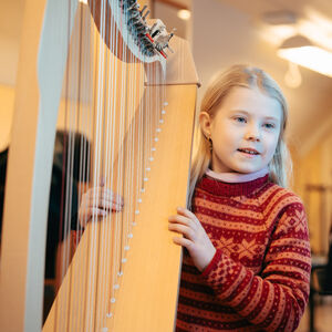 Barn spiller harpe