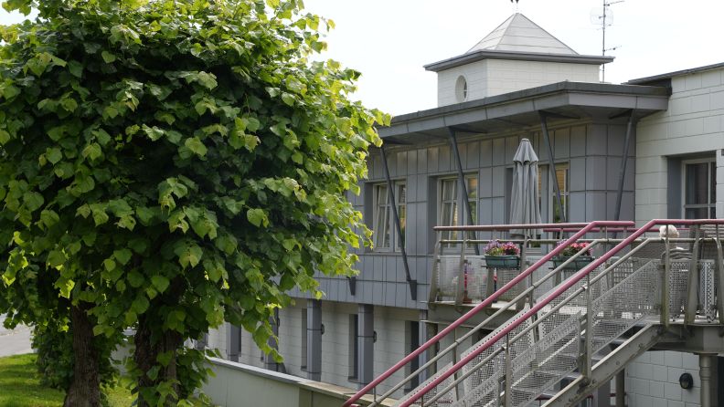 Uteområde til Lillohjemmet med flotte grønne trær foran bygget.