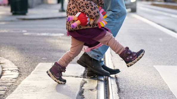 Barn og voksen går over veien