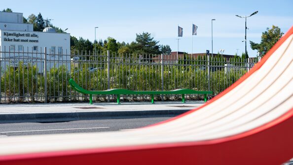 Grønn, lang benk foran moske