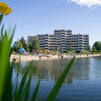 Svarttjern med badestrand og boligblokker i bakgrunn