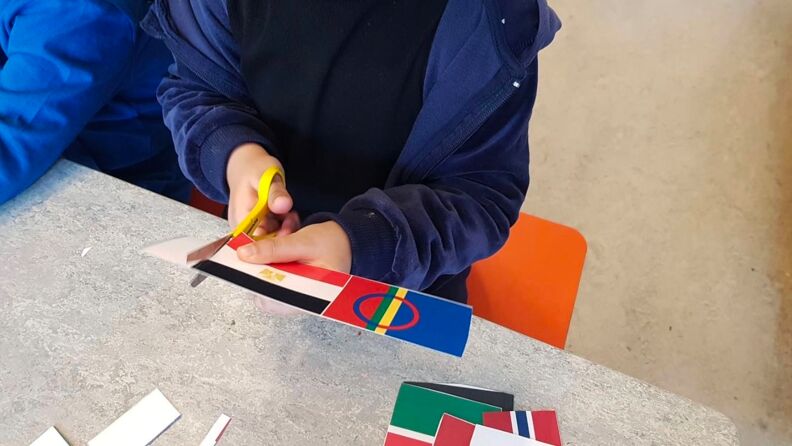 Et barn klipper ut flagg fra et ark
