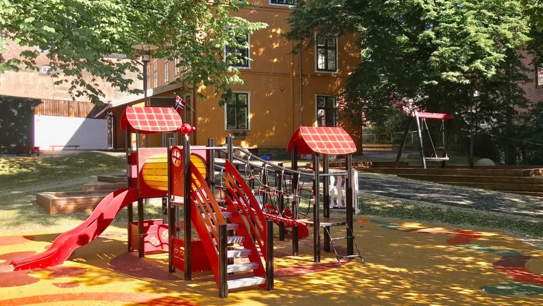 lekestativ i framgrunnen, barnehagen i bakgrunnen