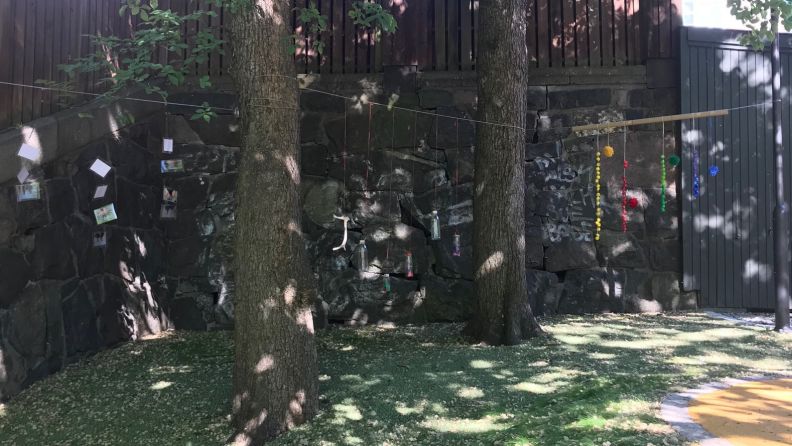 Sanseområde, to trær ved en vegg, ute