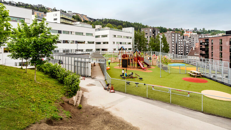 Oversiktsbilde av barnehagen, med lekeapparater