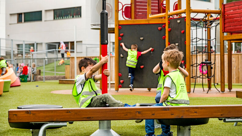 Barn leker i lekestativ ute