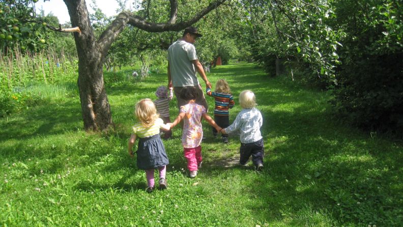Vøyensvingen barnehage - barn på tur under et frodig epletre