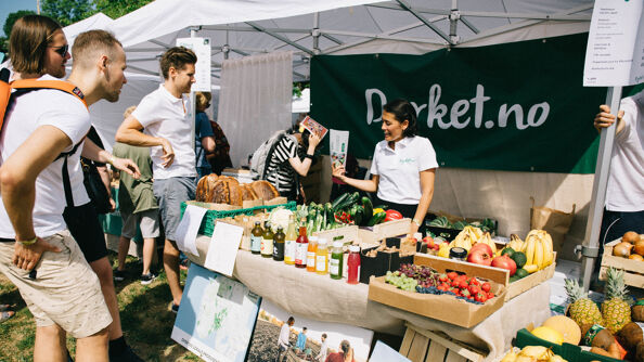 Mennesker ser på matvarer i en teltbod på Oslo vegetarfestival