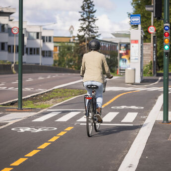 To syklister som sykler på en tilrettelagt sykkelvei.